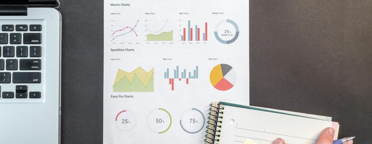 Printed analytics and chart examples on a desk next to a laptop, notebook, and pen, used as the featured image for a post about common SEO mistakes in Asheville.